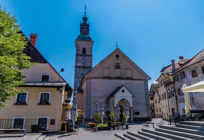 De St. Jacobskerk of Sveti Jakoba op het Cankarjev trg in het middeleeuwse Škofja Loka in Slovenië