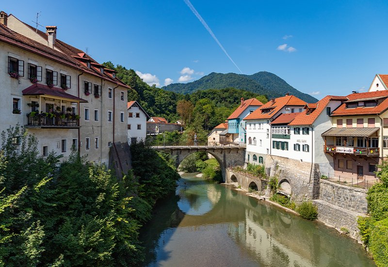 De kapucijner brug en de nieuwe stadsbrug over de Selška Sora in Puštal in het middeleeuwse Škofja Loka in Slovenië